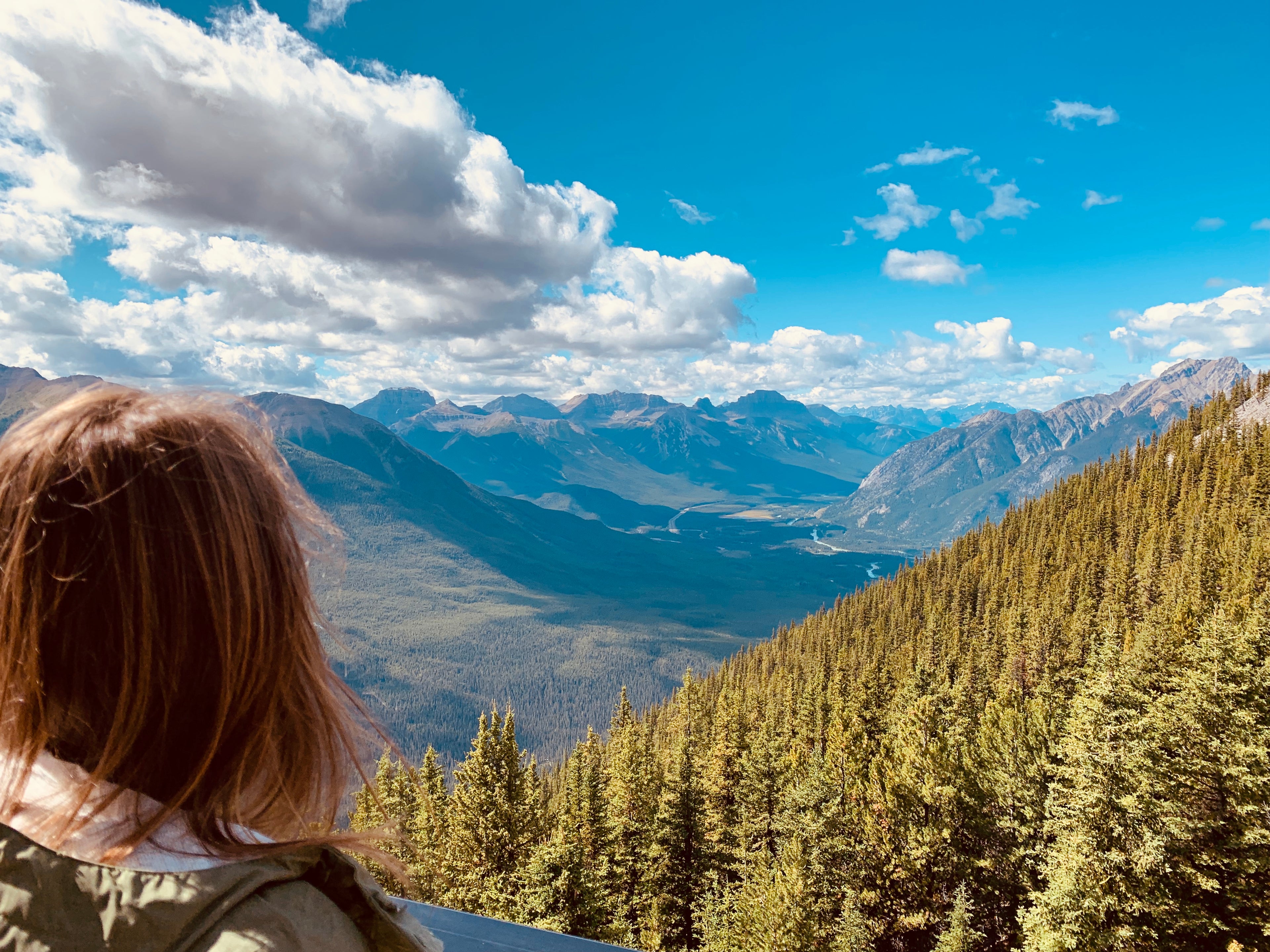 Woman looking from a mountain across the valley in Banff